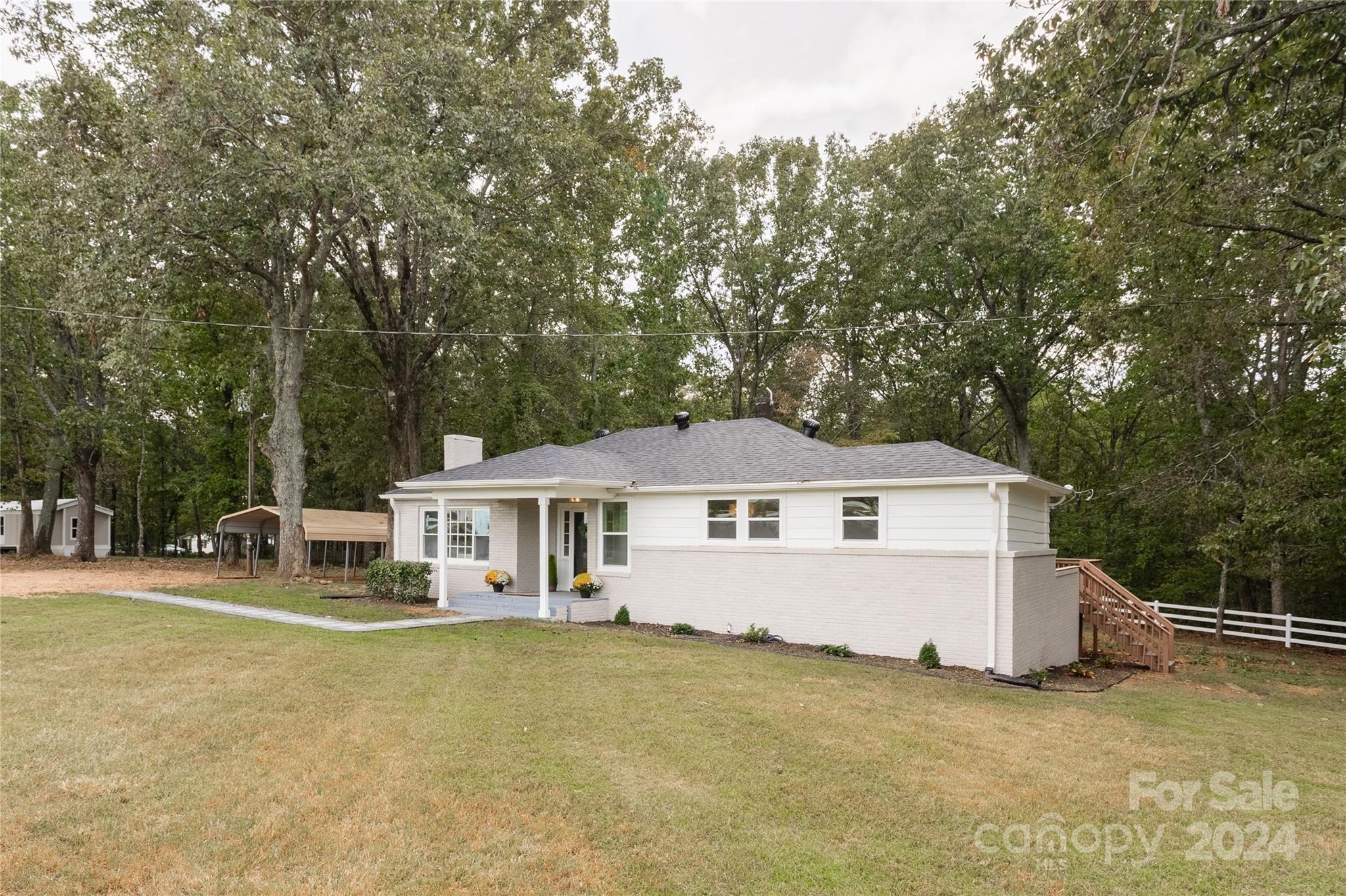 a front view of a house with a garden and trees