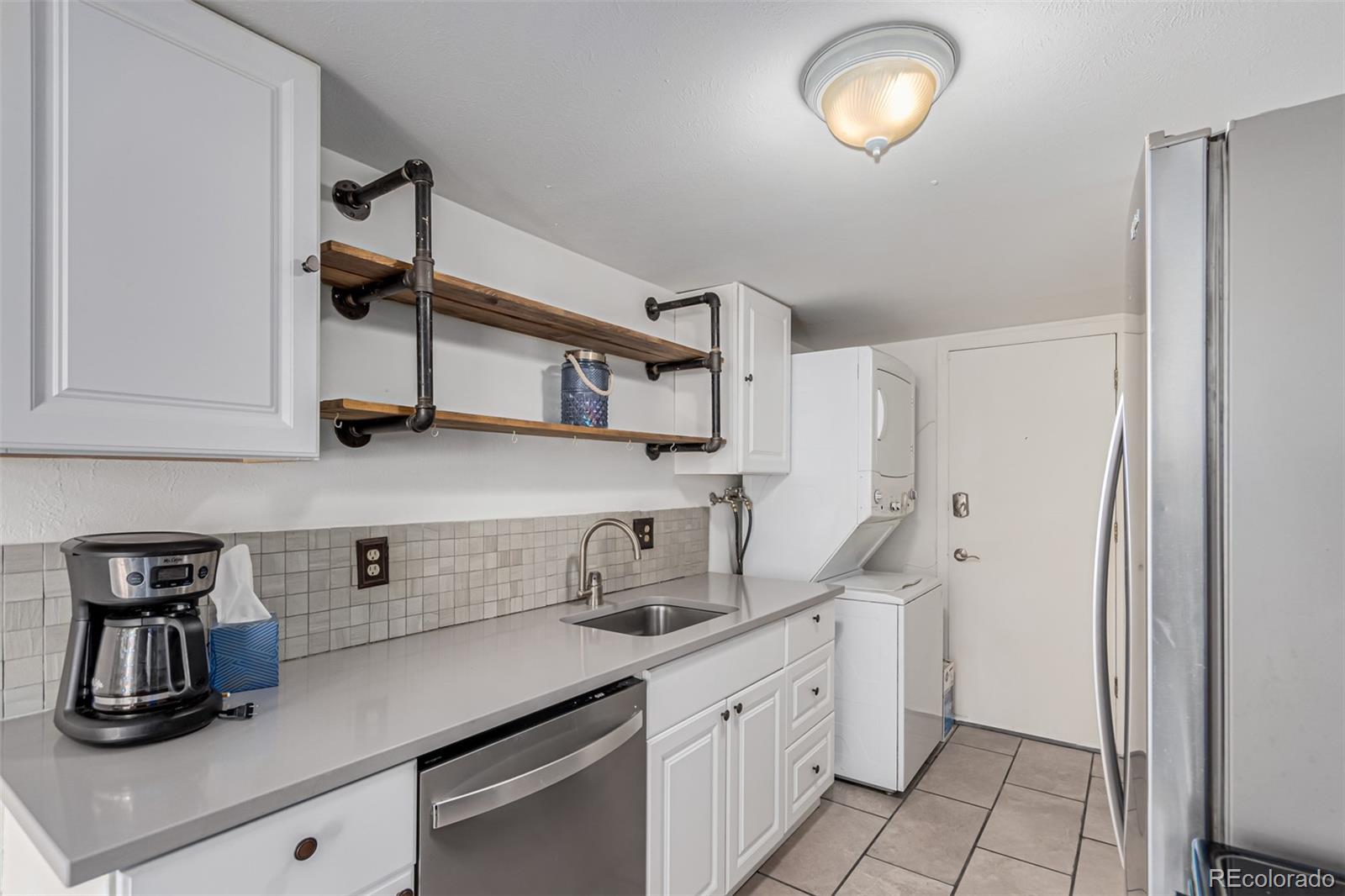 a kitchen with stainless steel appliances a sink a refrigerator and cabinets