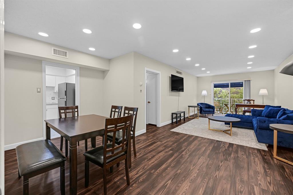 a living room with furniture a wooden floor and a potted plant