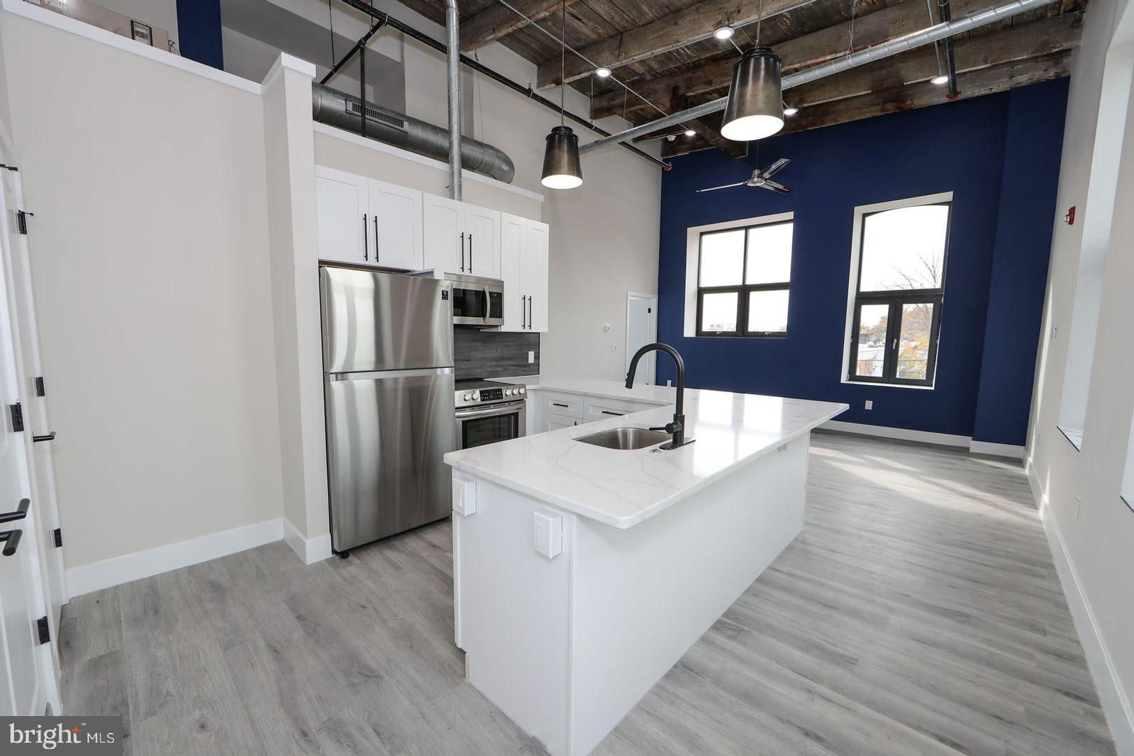 a large white kitchen with a large window