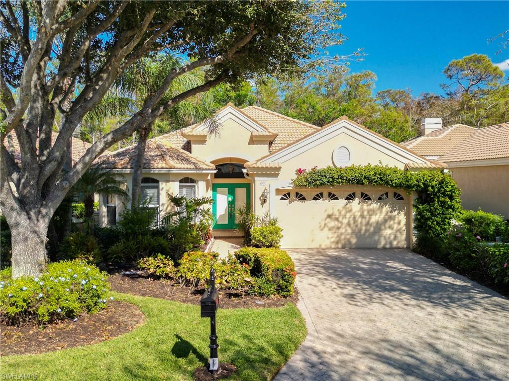 a front view of a house with a yard and a garden