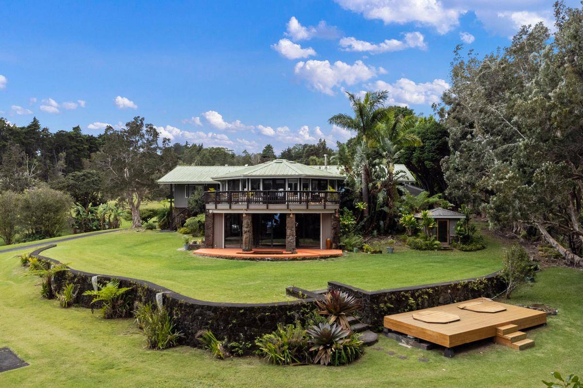 a view of a swimming pool and lounge chairs in back yard of the house