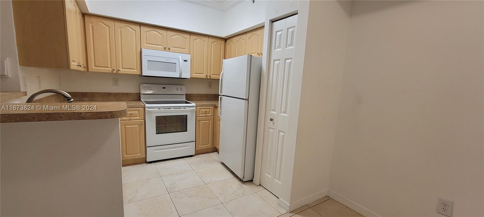 a kitchen with a refrigerator sink and cabinets