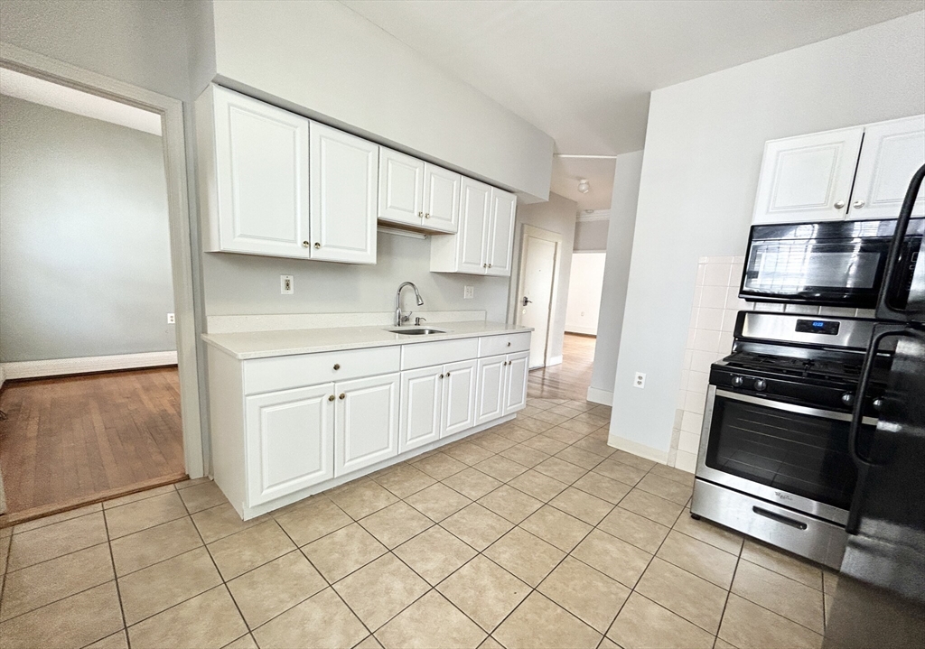 a kitchen with stainless steel appliances a stove a sink and a refrigerator