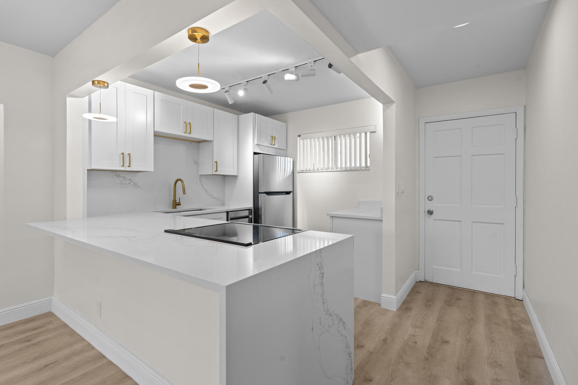 a kitchen with kitchen island a sink stove and refrigerator