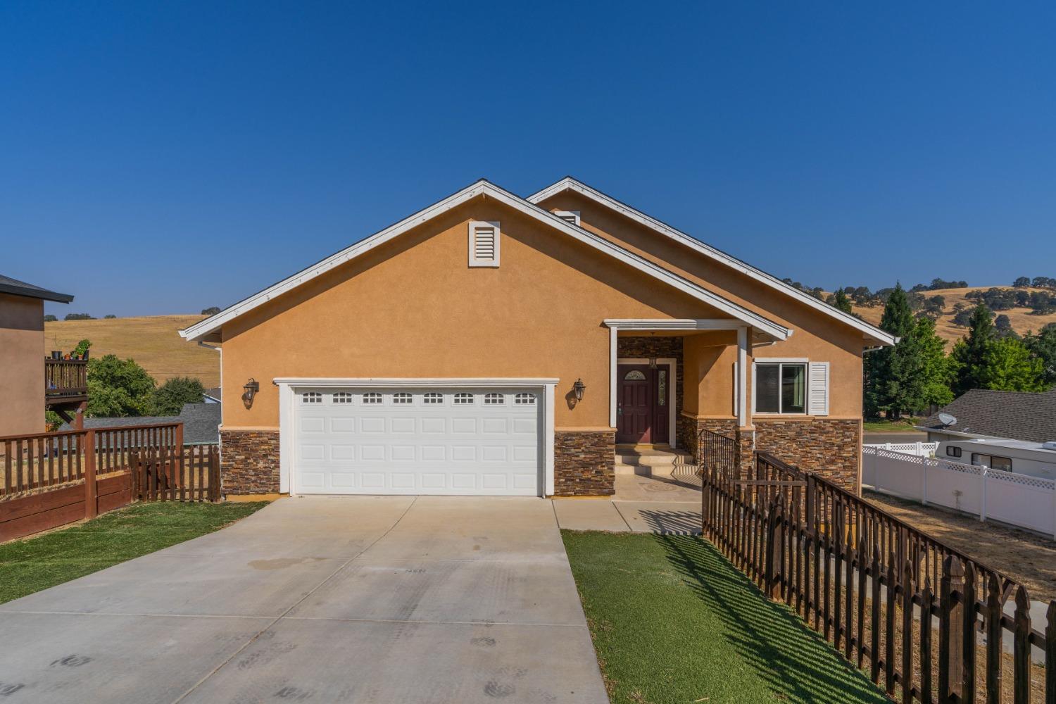 a view of a house with wooden fence next to a yard