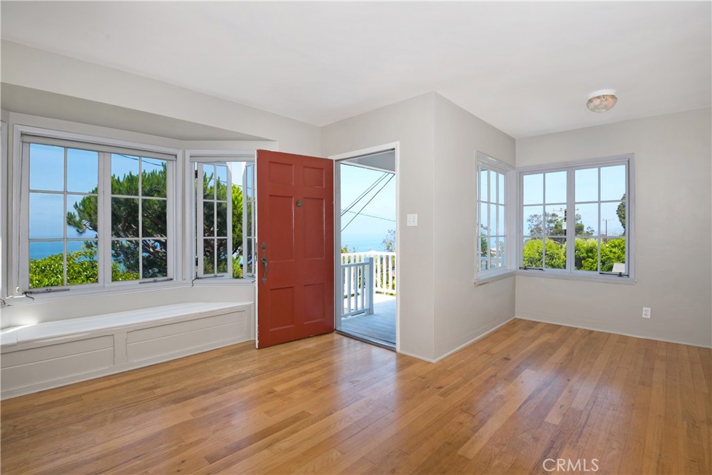 a view of hallway with wooden floor and windows