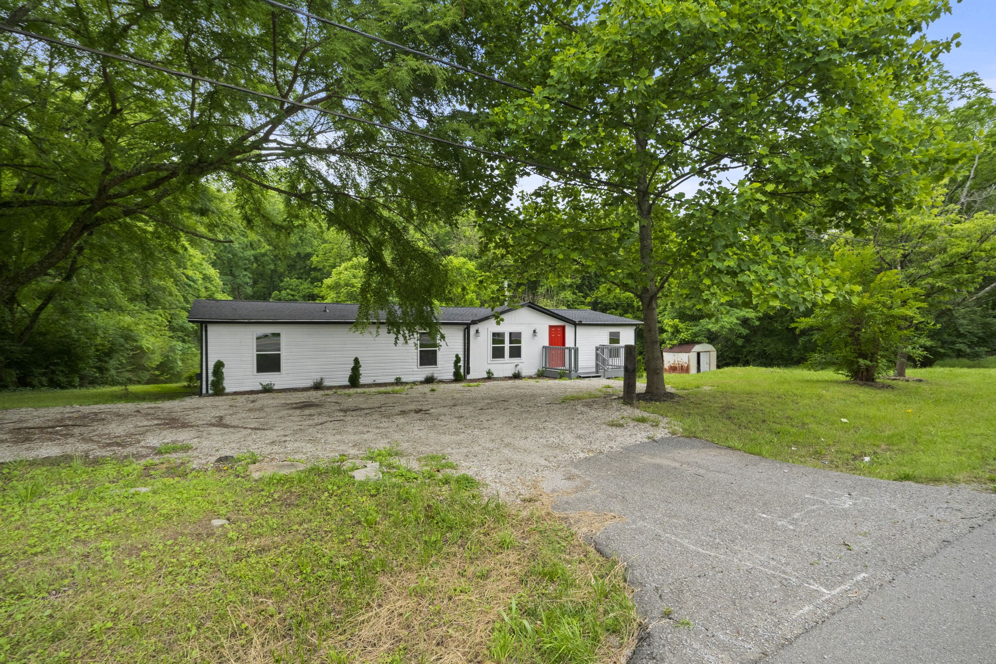 a view of a house with a yard and large tree