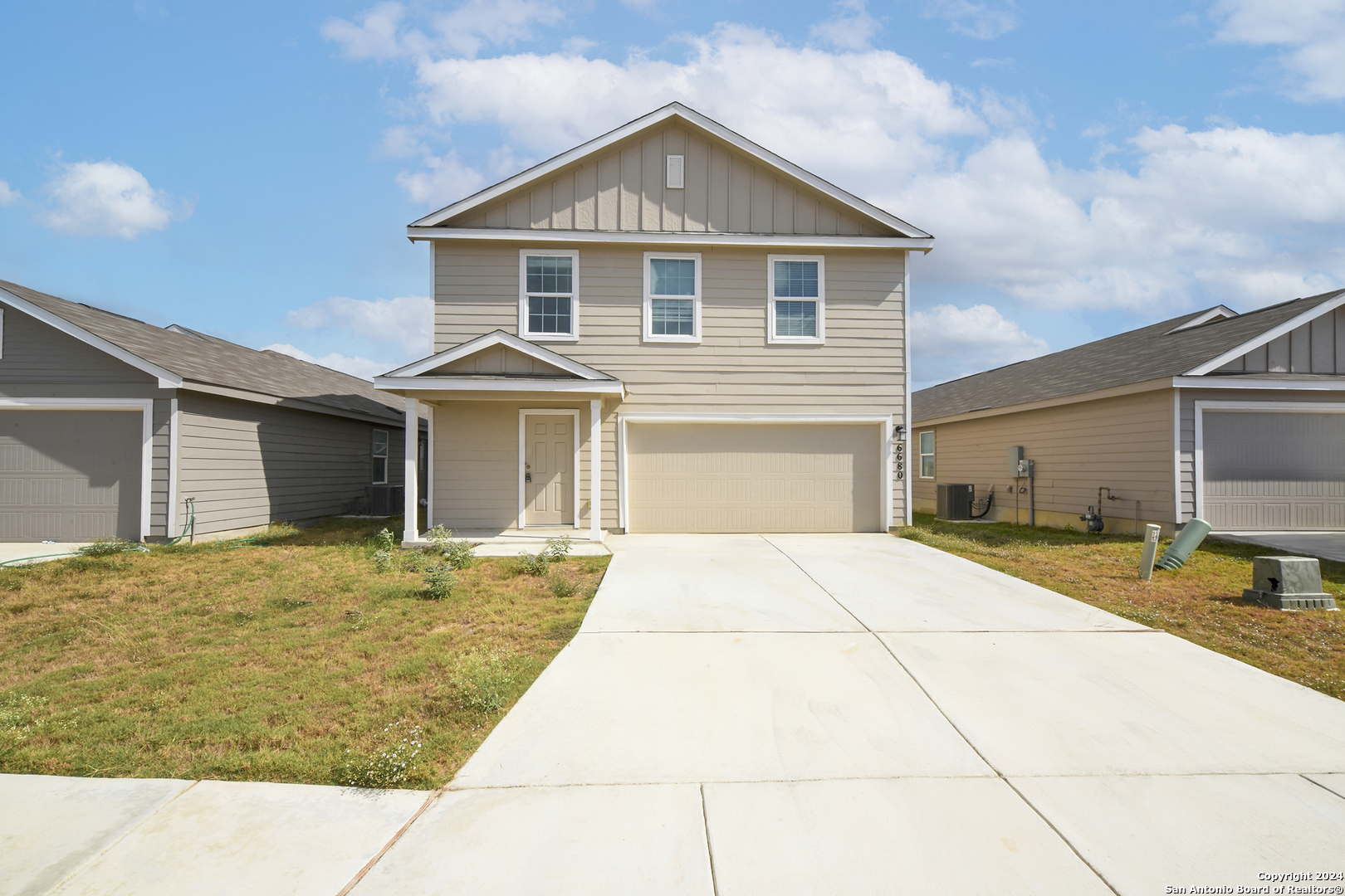 a front view of a house with a yard and garage