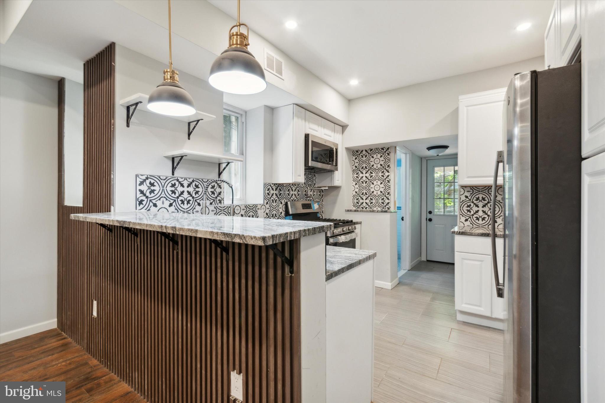 a kitchen with stainless steel appliances granite countertop a refrigerator and a sink