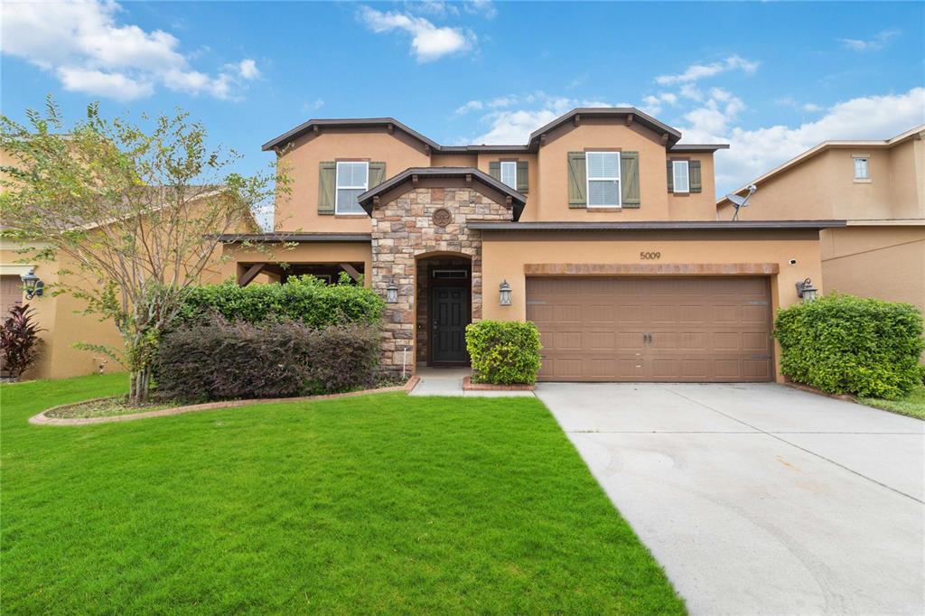 a front view of a house with a yard and garage