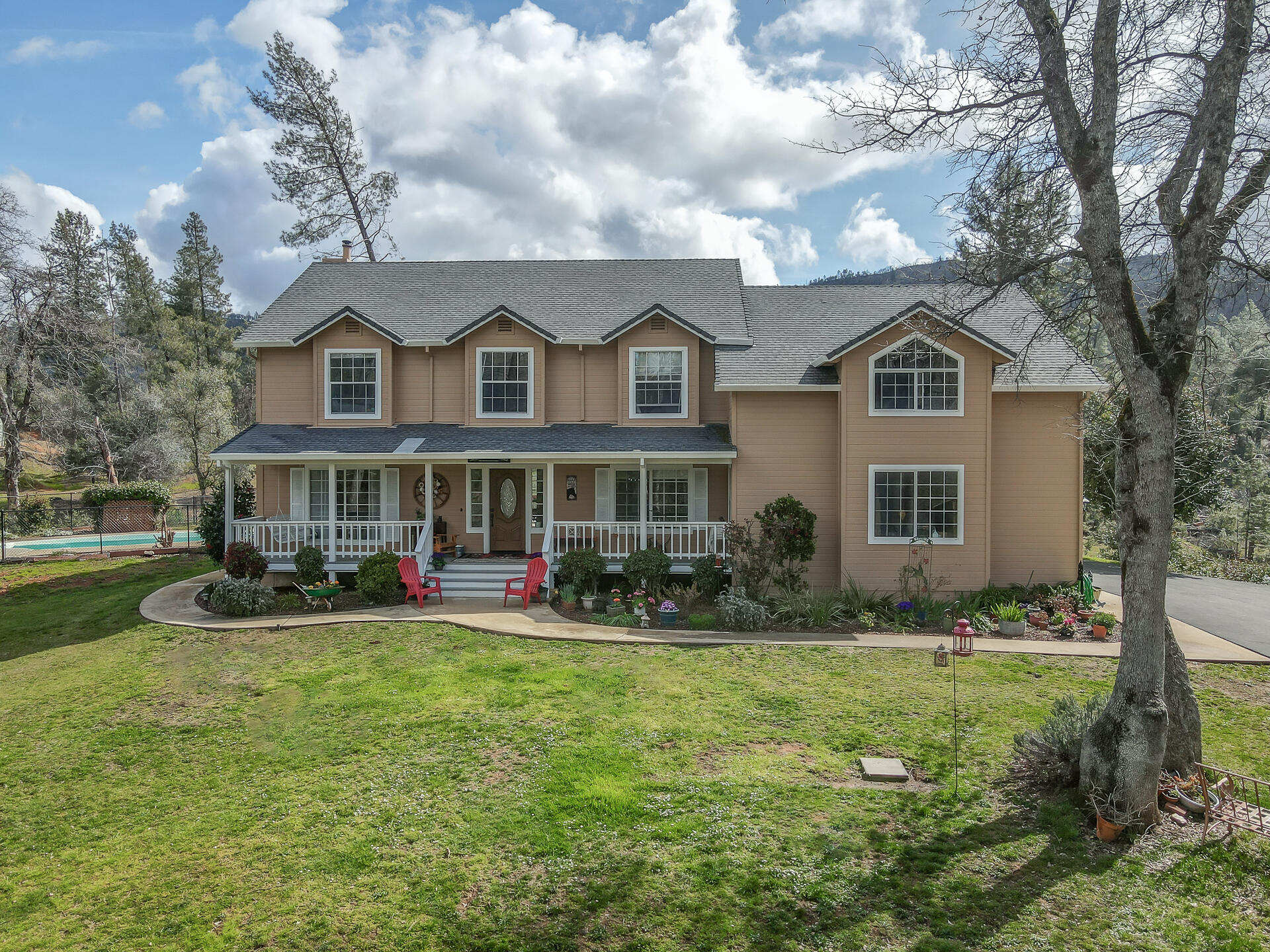 a front view of a house with garden and trees