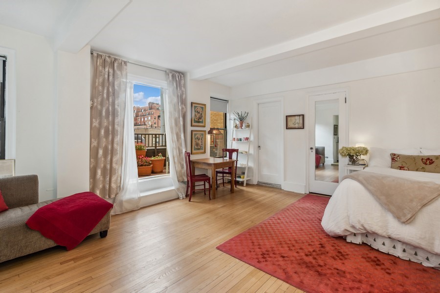 a bedroom with a bed and large windows