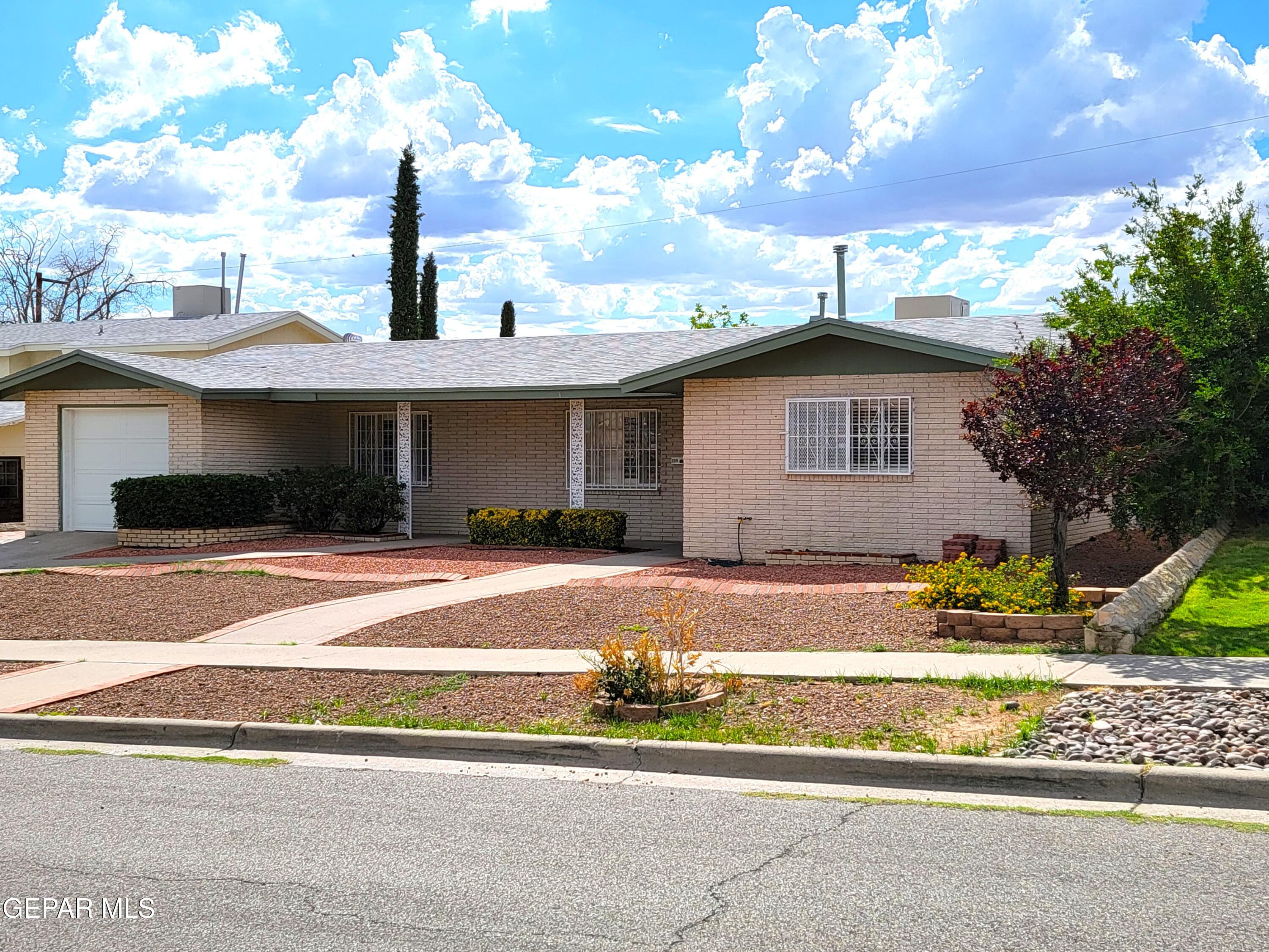 a view of a house with a patio and a yard