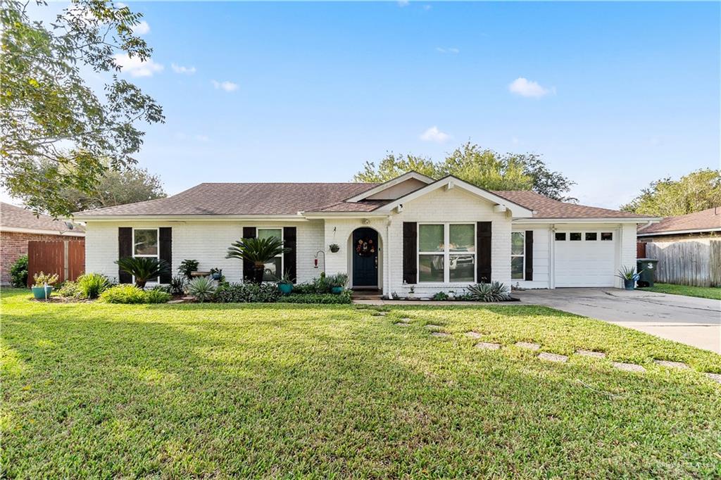 Ranch-style house with a garage and a front lawn