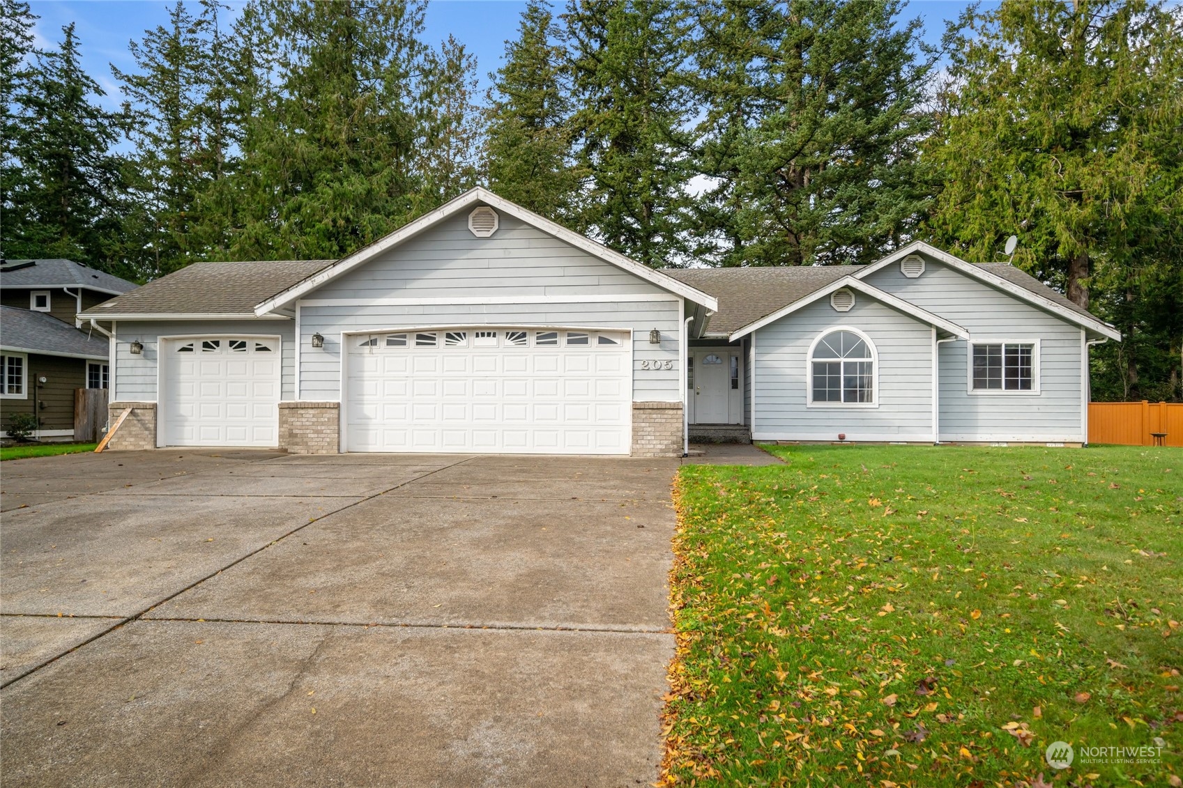 a view of a house with a yard and large trees