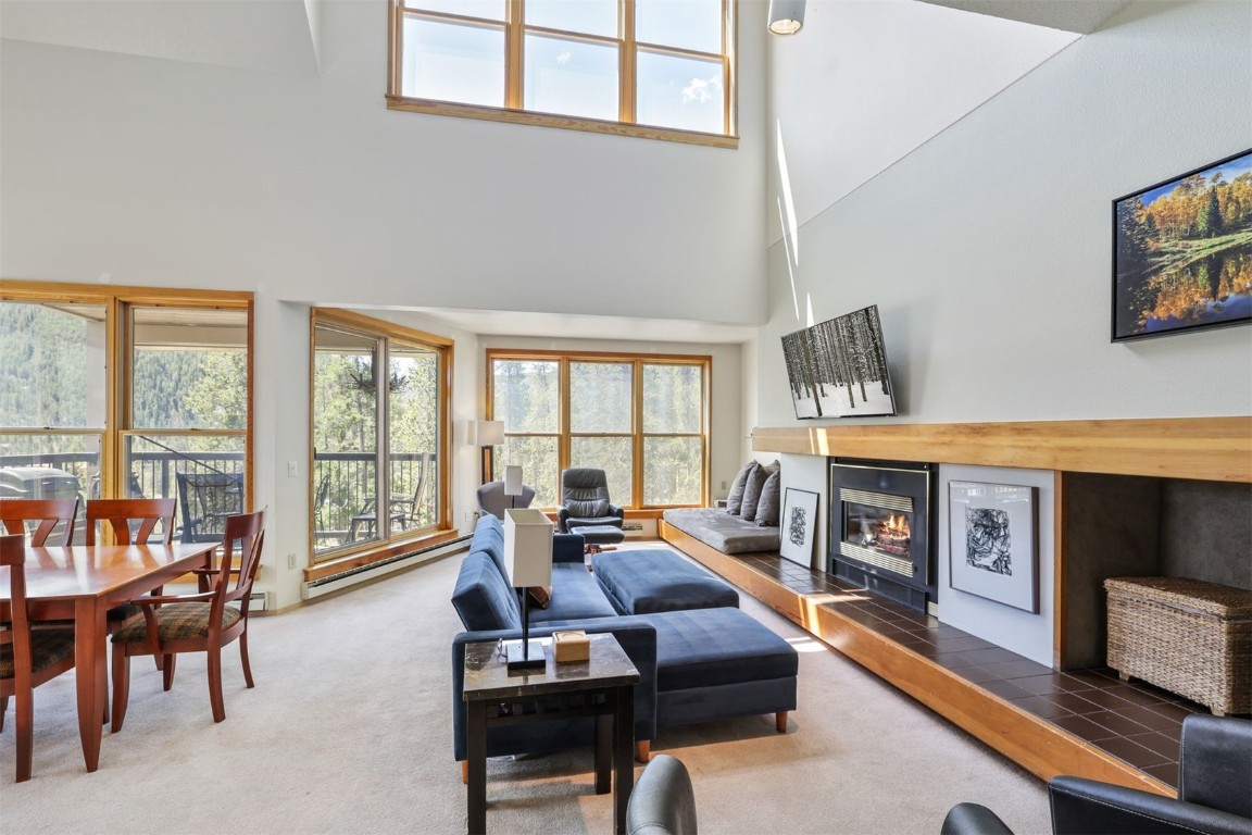 a living room with furniture a flat screen tv and a floor to ceiling window