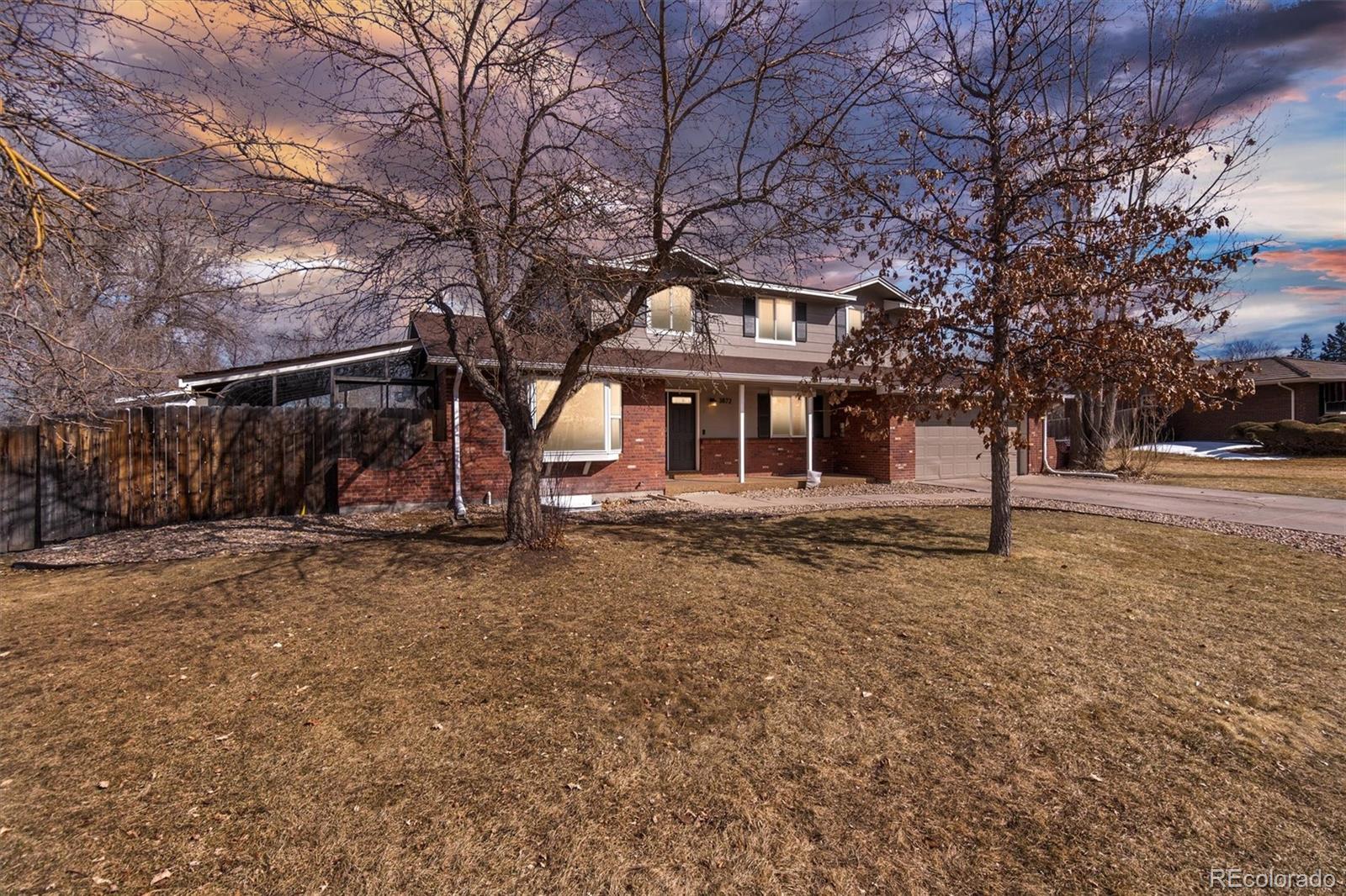 a front view of a house with a tree