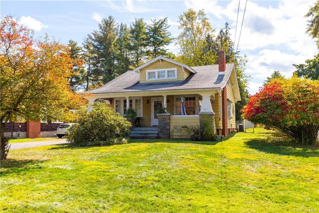 a front view of a house with yard and green space