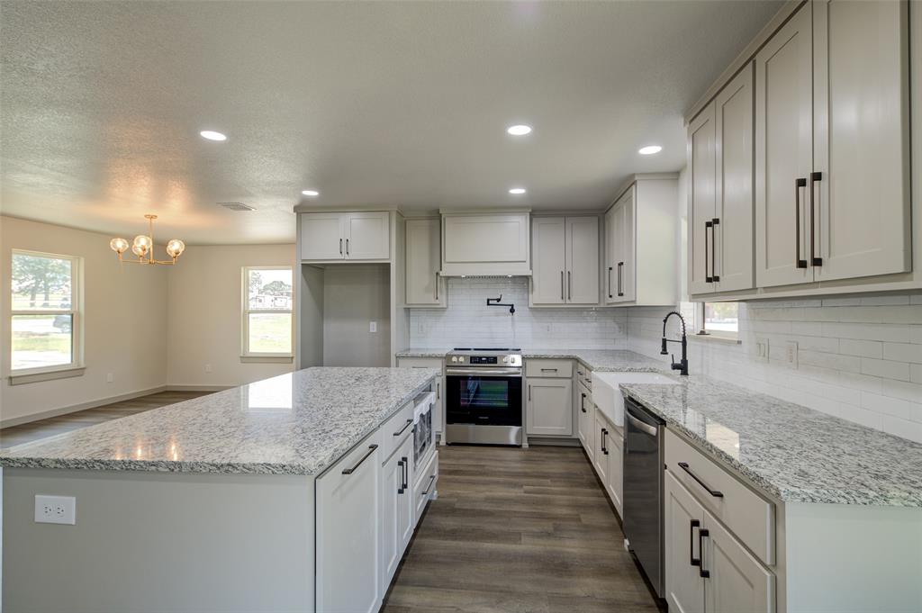 a kitchen with stainless steel appliances granite countertop a sink stove and cabinets