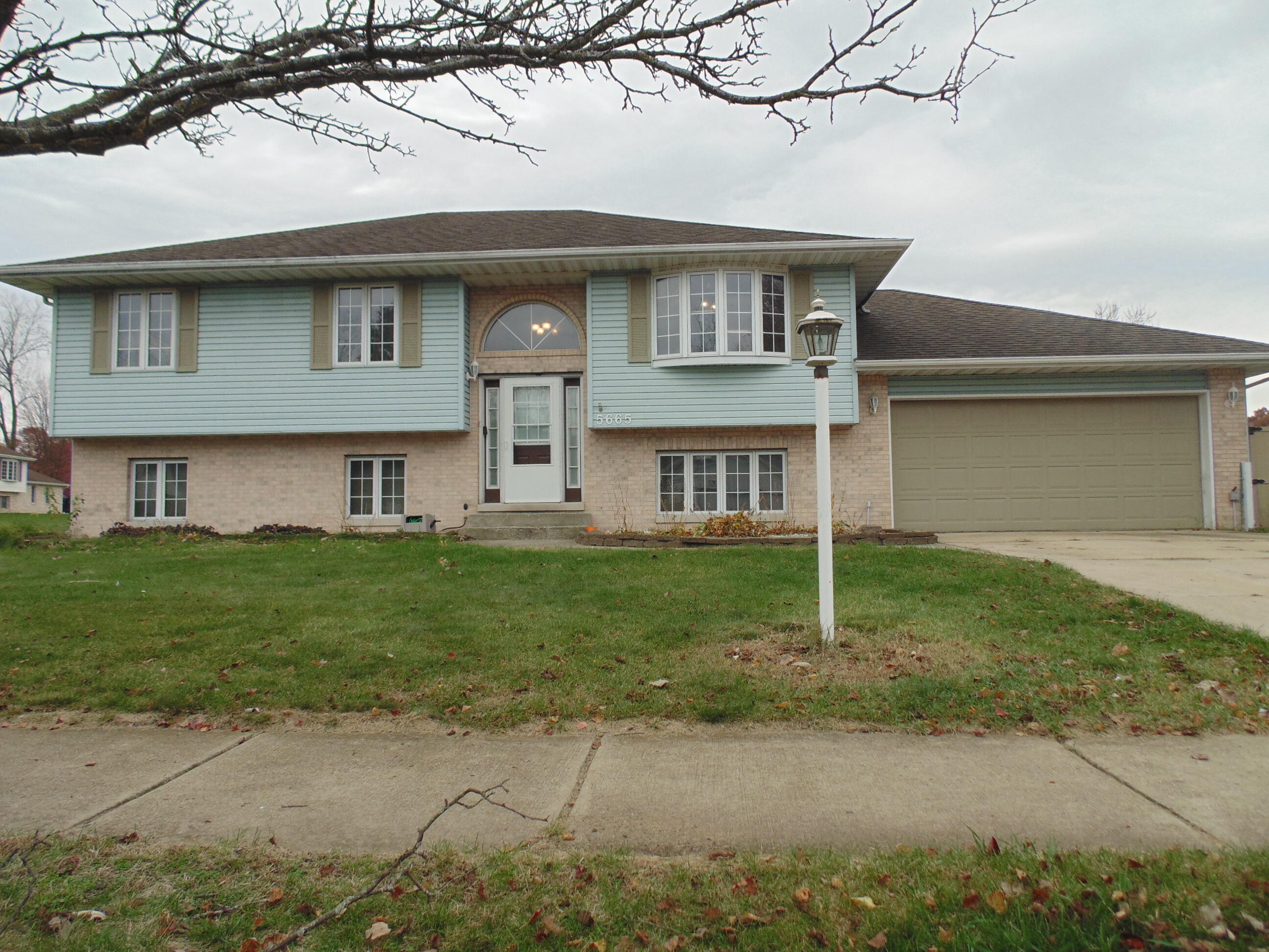 a front view of a house with a garden and yard