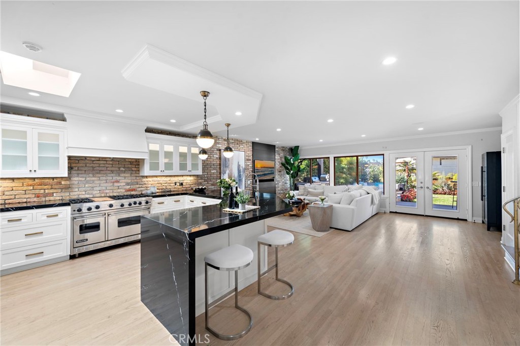 a large kitchen with stainless steel appliances granite countertop a lot of counter space and wooden floor