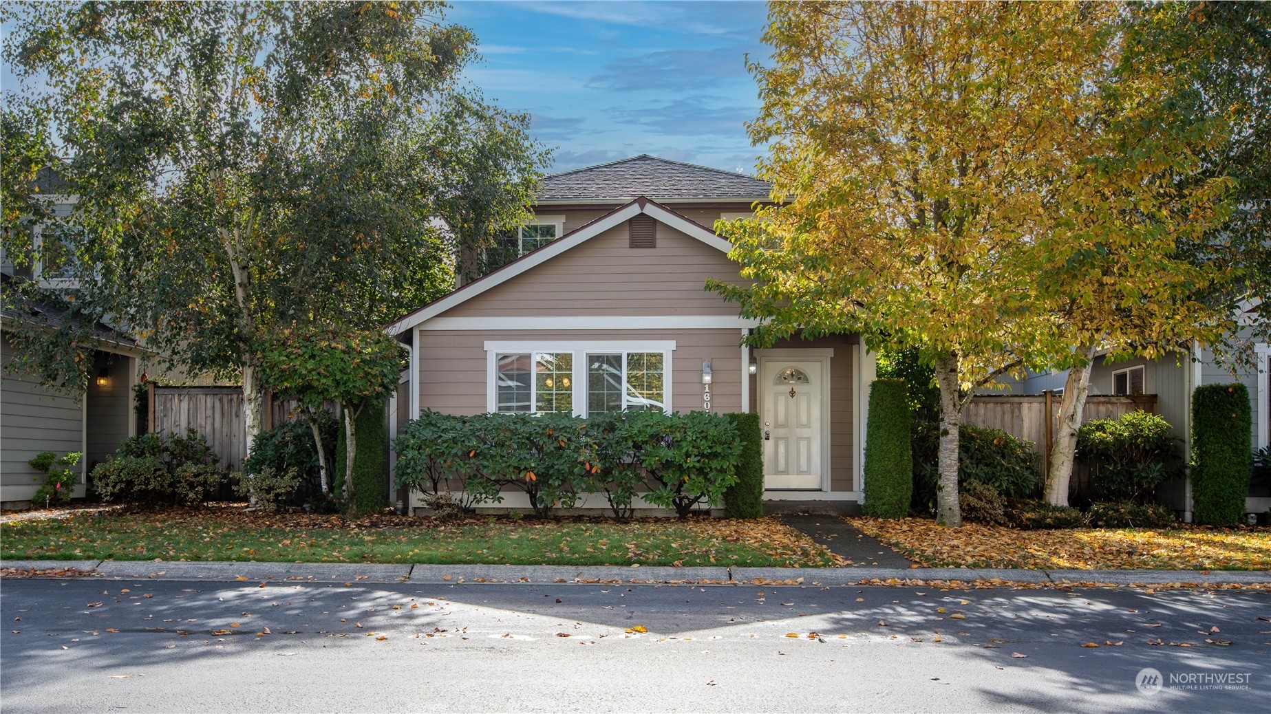 a front view of a house with a yard and tree s