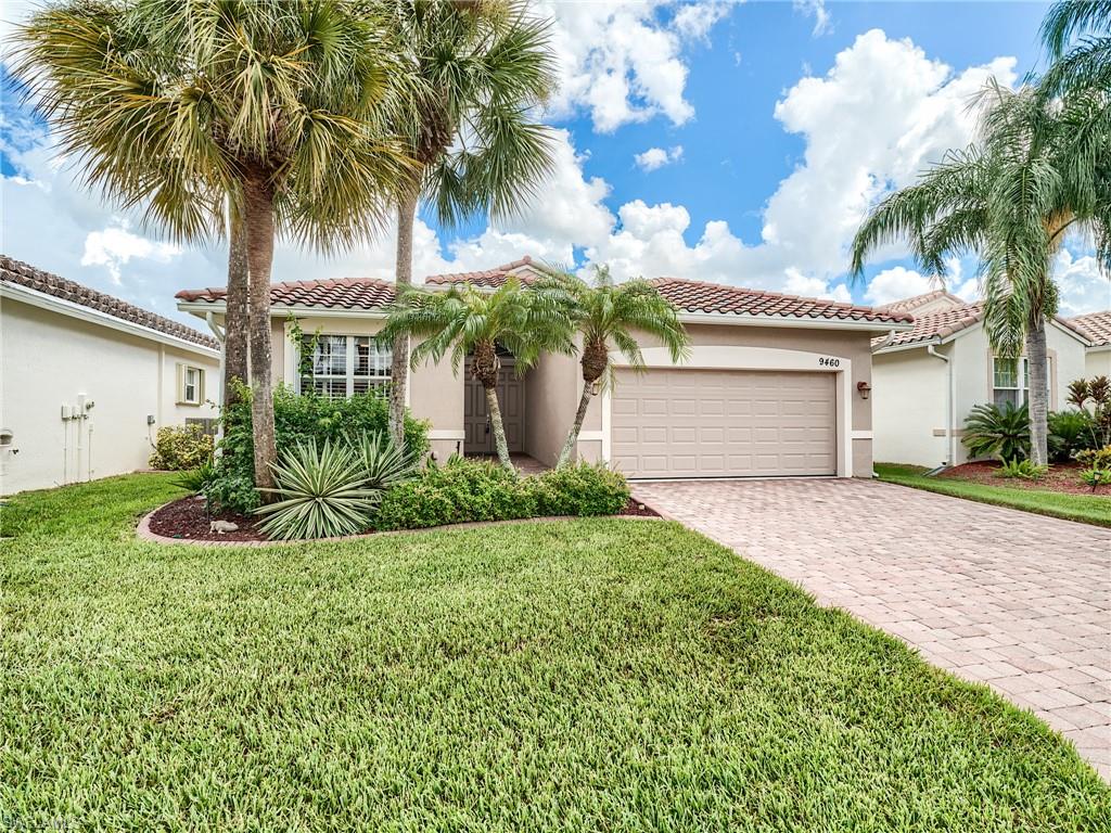 a view of a house with a yard and palm trees