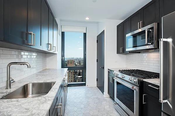 a kitchen with granite countertop a sink and stove top oven