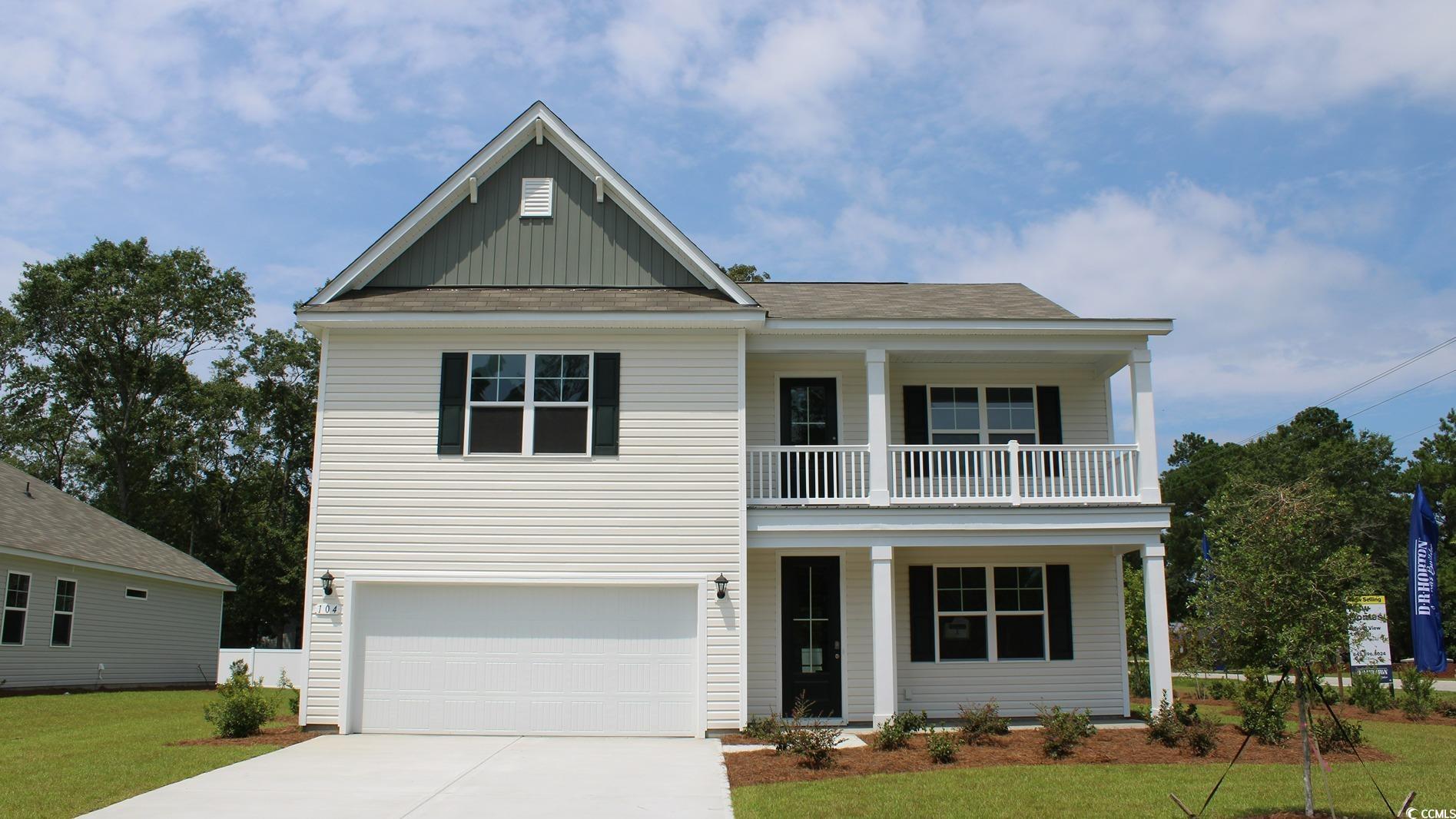 View of front of property featuring a balcony, a g