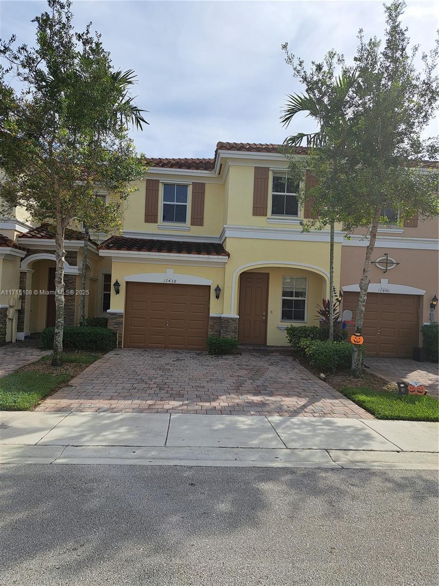 a front view of a house with a yard and garage