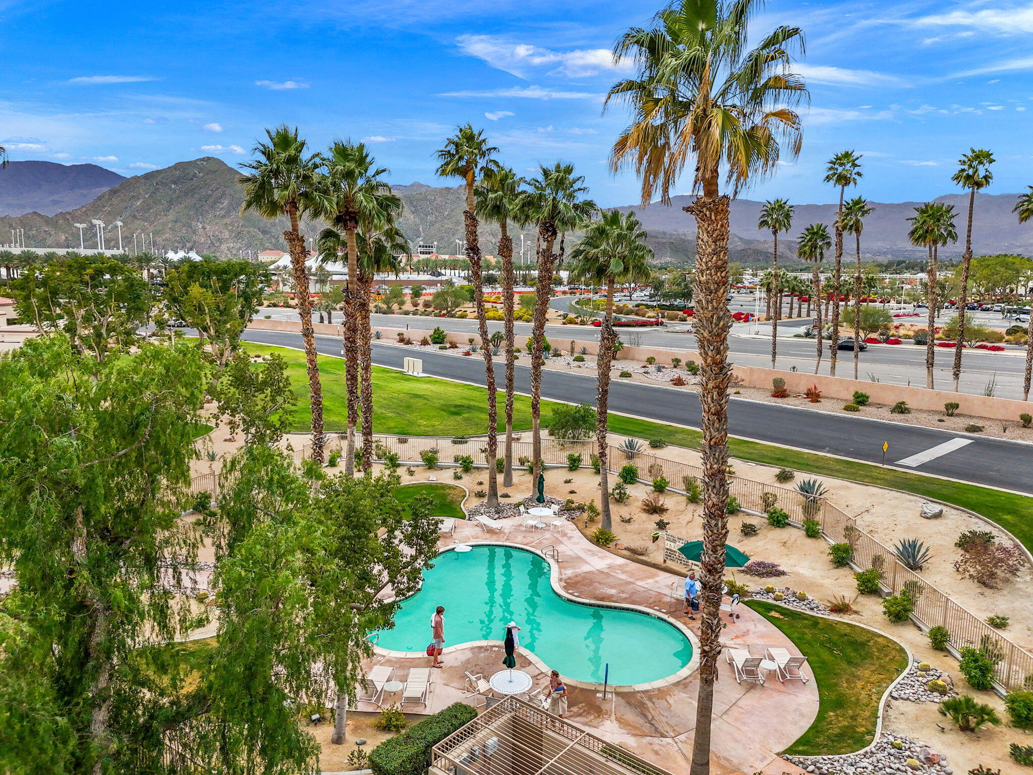 a view of a swimming pool with a lawn chairs under an umbrella