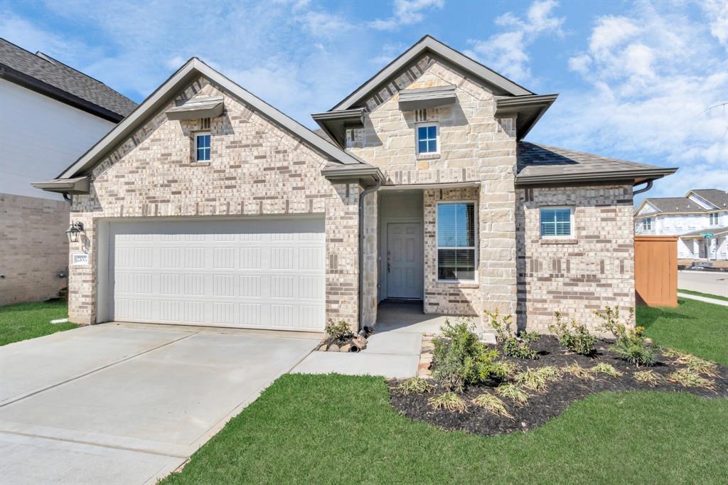 a front view of a house with a yard and garage