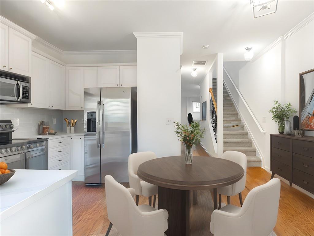 a kitchen with stainless steel appliances a table and chairs