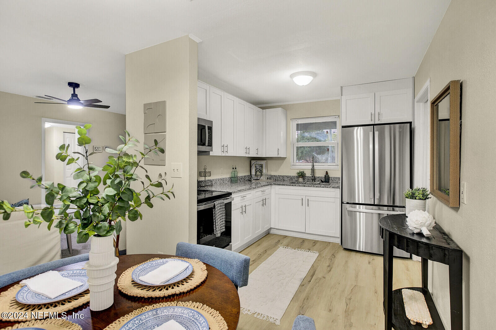 a kitchen with a refrigerator and a white table chairs