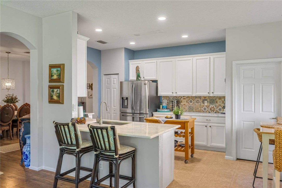 a kitchen with a table chairs refrigerator and cabinets