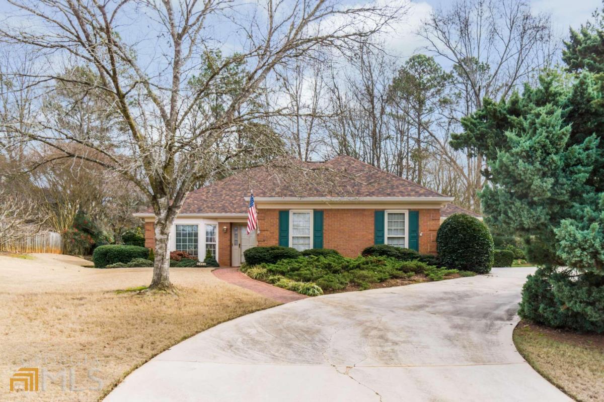 a front view of house with yard and trees around