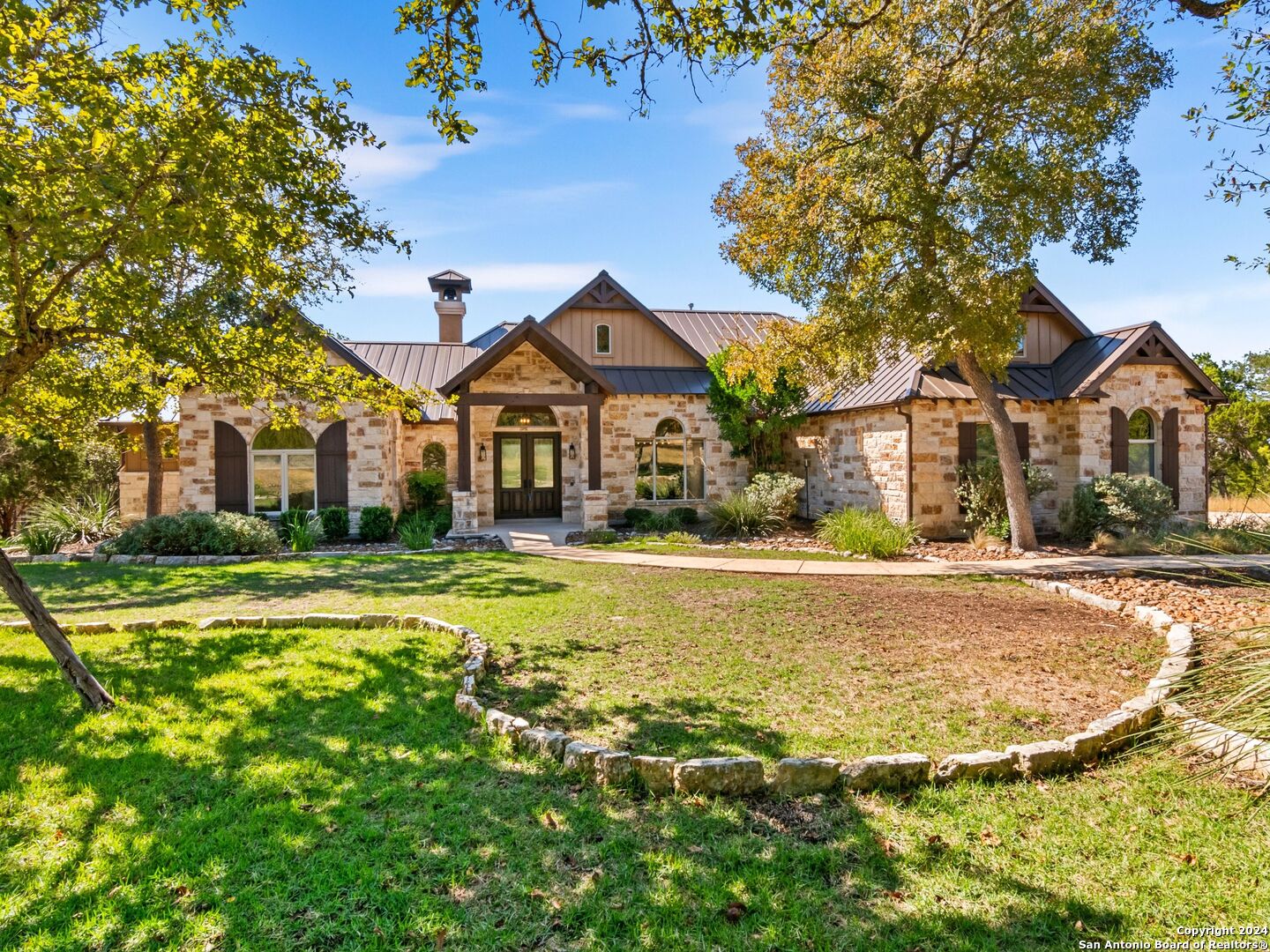 a view of a large house with a big yard and large tree