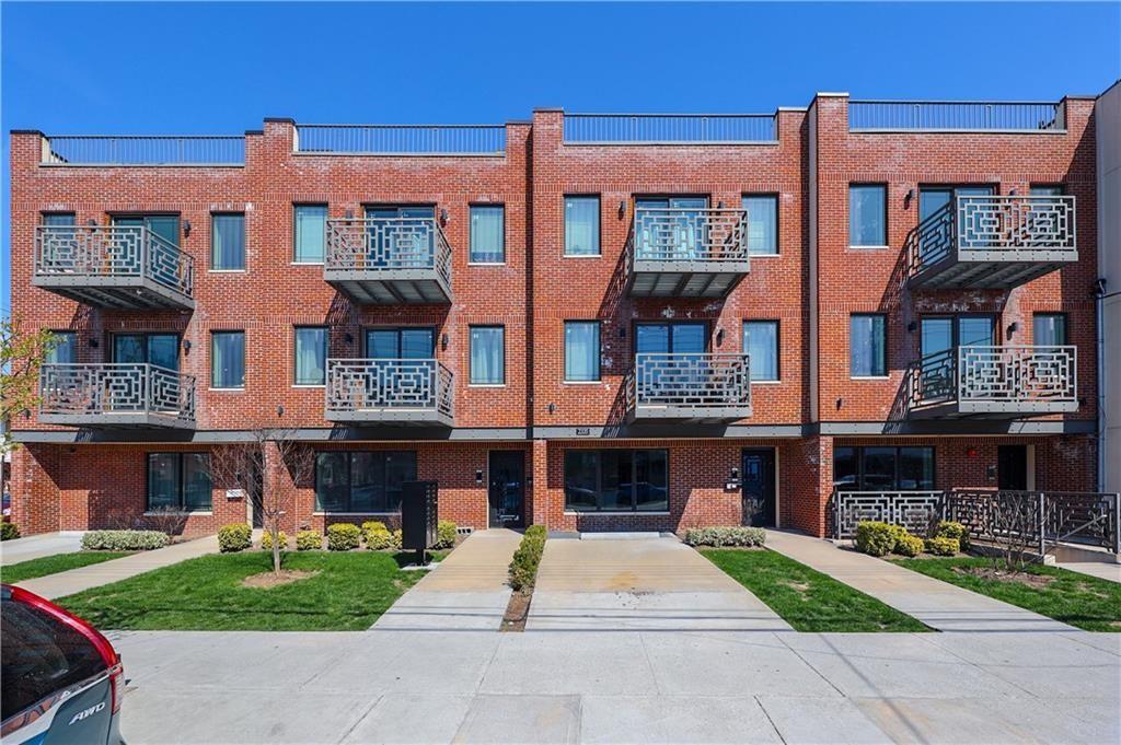 a front view of a brick building with a yard