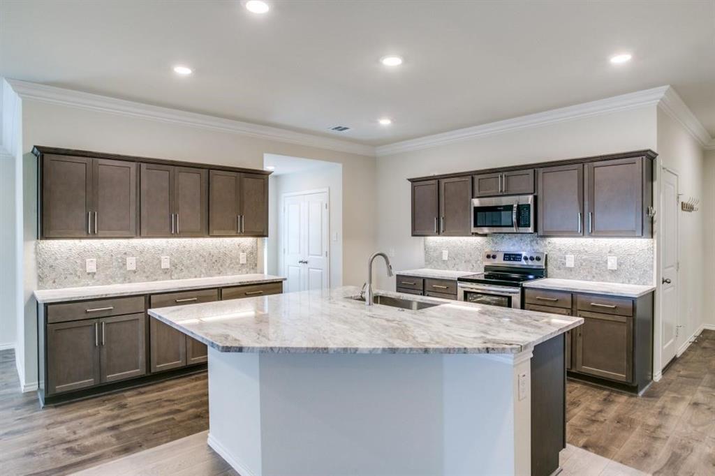 a kitchen with stainless steel appliances a sink stove and cabinets