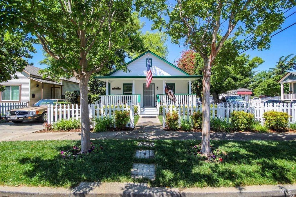 a front view of a house with yard and green space