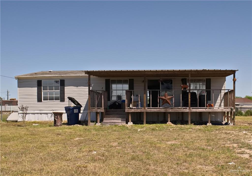 a view of a house with large windows and yard