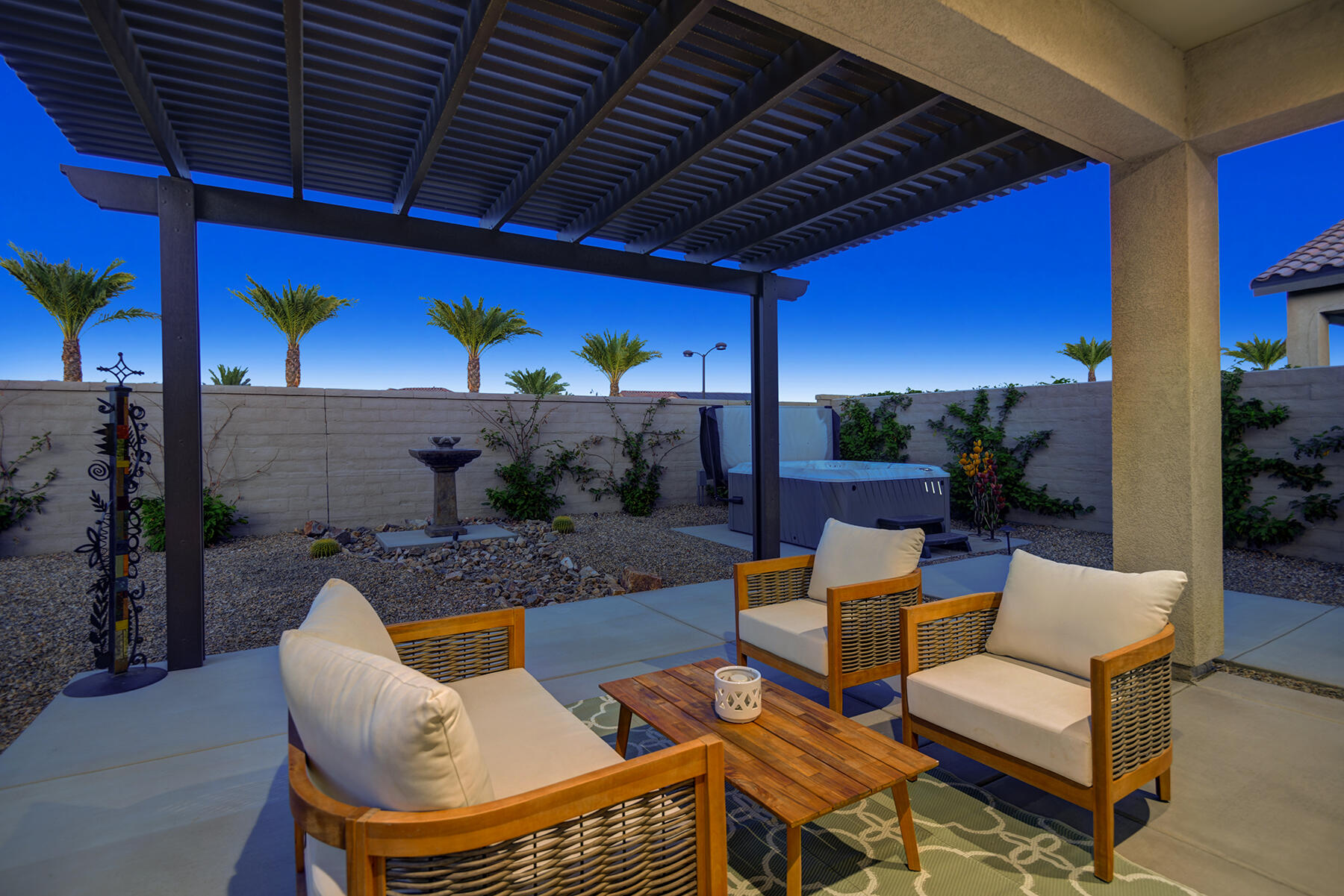 a view of a patio with couches table and chairs under an umbrella with a barbeque