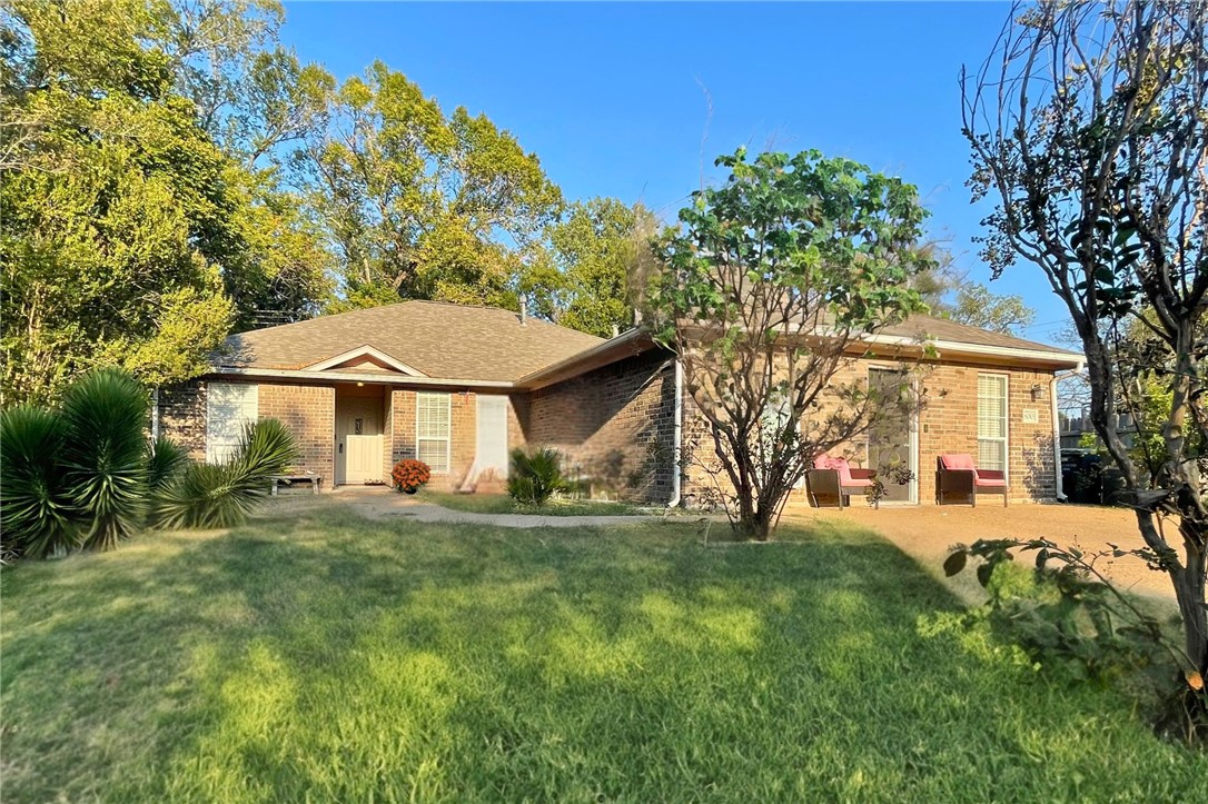 Ranch-style home featuring a front lawn and a pati