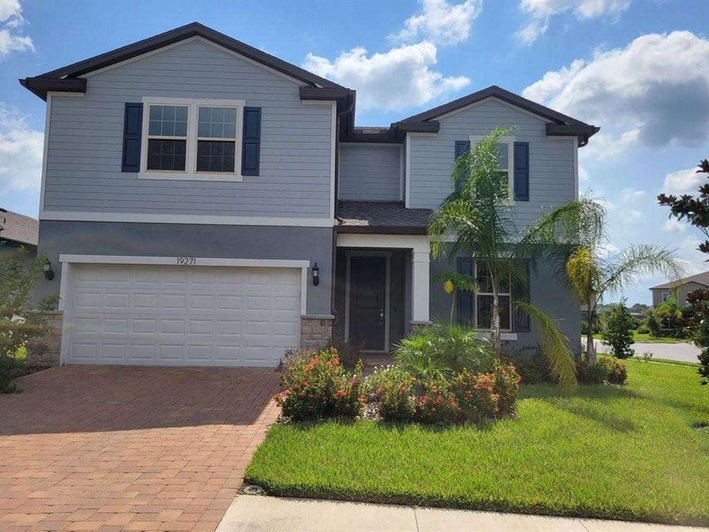 a front view of a house with a yard and garage