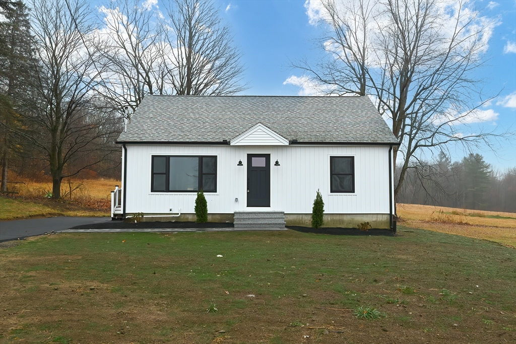 a front view of a house with a garden