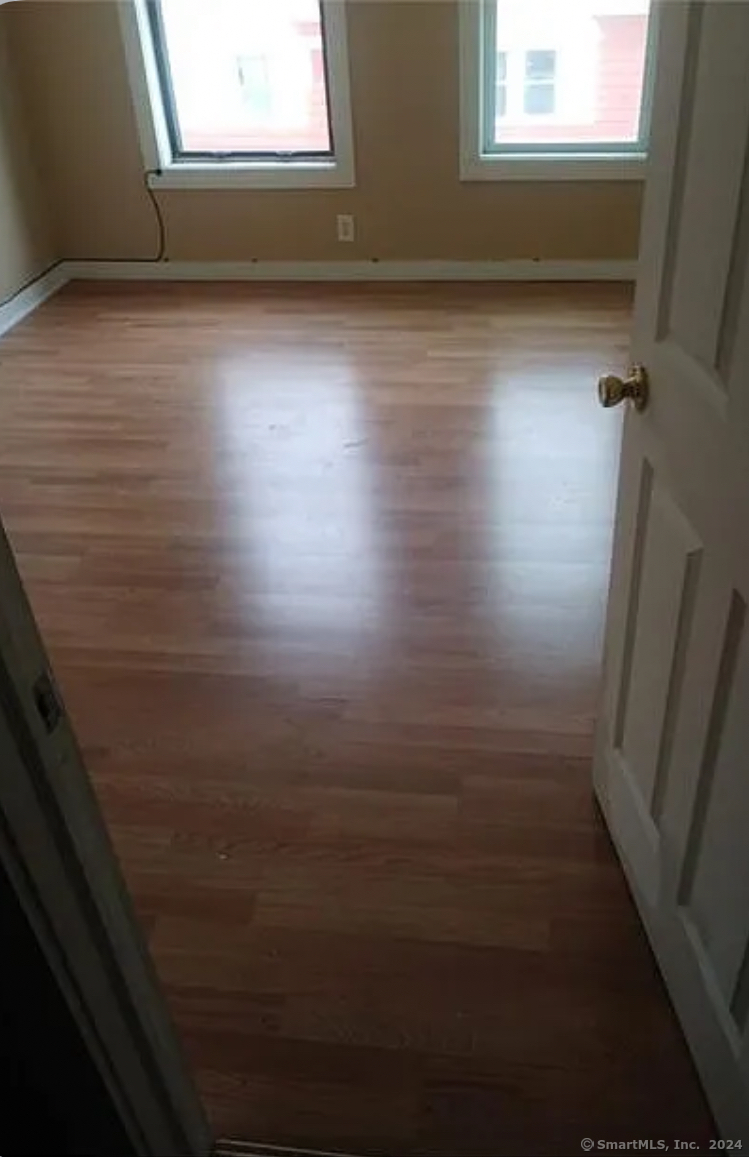 a view of a room with wooden floor and window