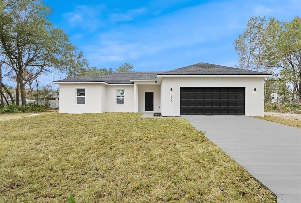 a front view of a house with yard and garage