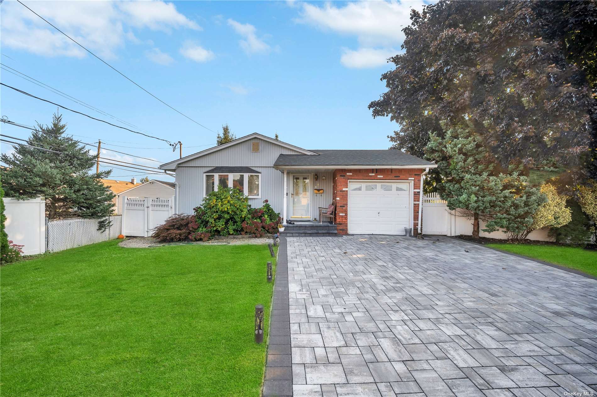 a view of a house with a yard and large tree