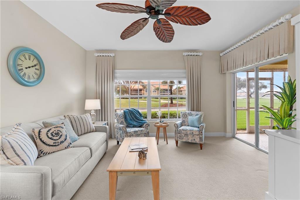 Carpeted living room with ceiling fan